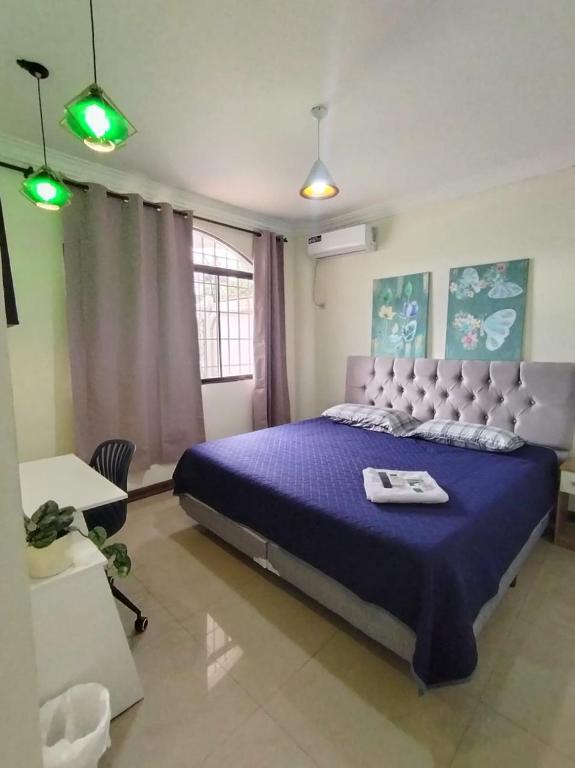 a bedroom with a large bed with a purple comforter at Casa Florencia Hab 1 Florencia in Guayaquil