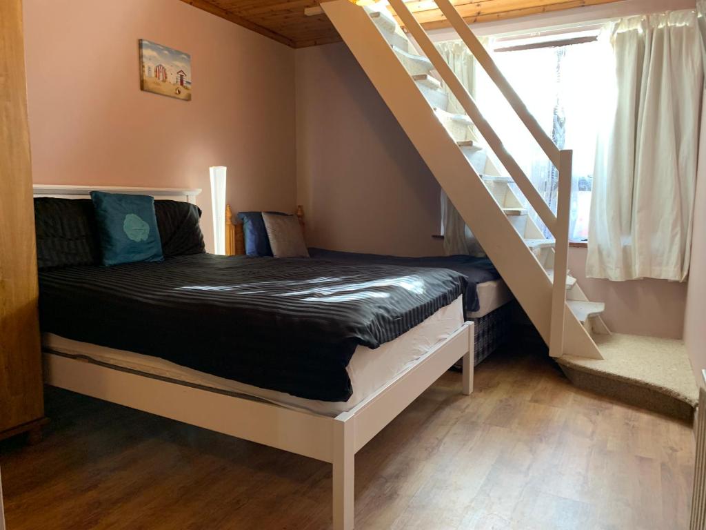 a bed in a room with a staircase at Azure Lodge in Bundoran