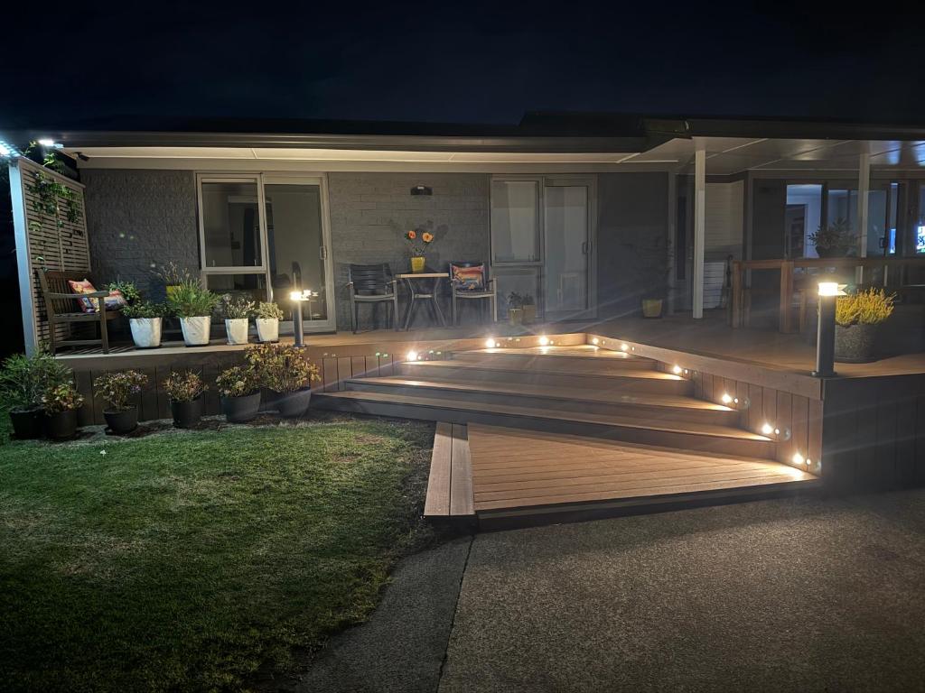 a deck with lights on a house at night at B&B at whitbourne in Otorohanga