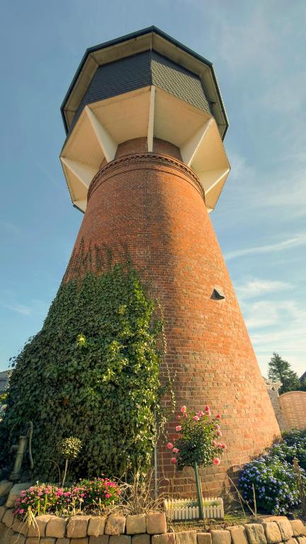 a large brick tower with a bush in front of it at Einzigartig übernachten im Wasserturm an der Elbe in Stelle