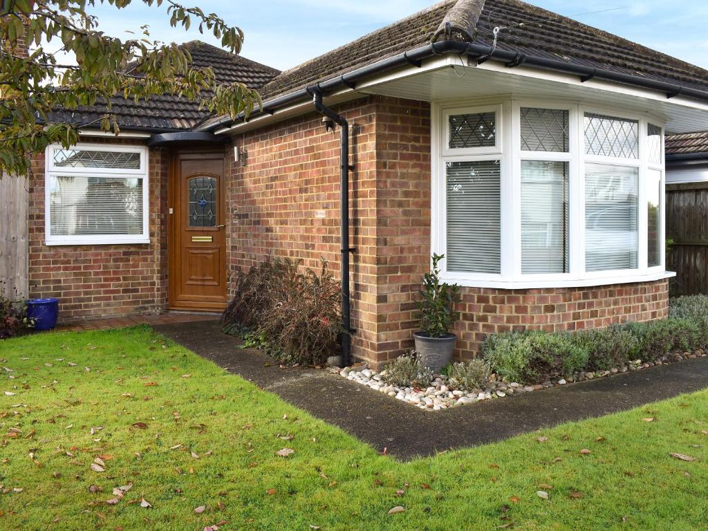 a brick house with a brown door and a yard at Why Not in Canterbury