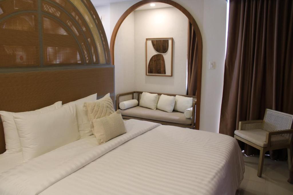 a bedroom with a large white bed and a couch at Dahican Beach Resort and Spa in Sampong