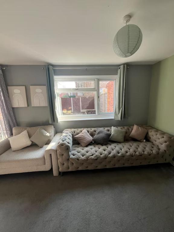 a living room with a couch in front of a window at Cosy Home Contractors, Relocations, Coffee Machine in Beoley