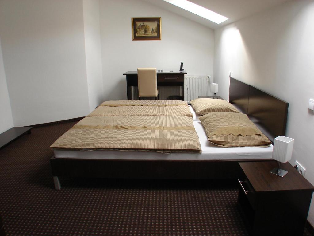 - une chambre avec un lit et un bureau dans l'établissement Rooms Levicki, à Slavonski Brod