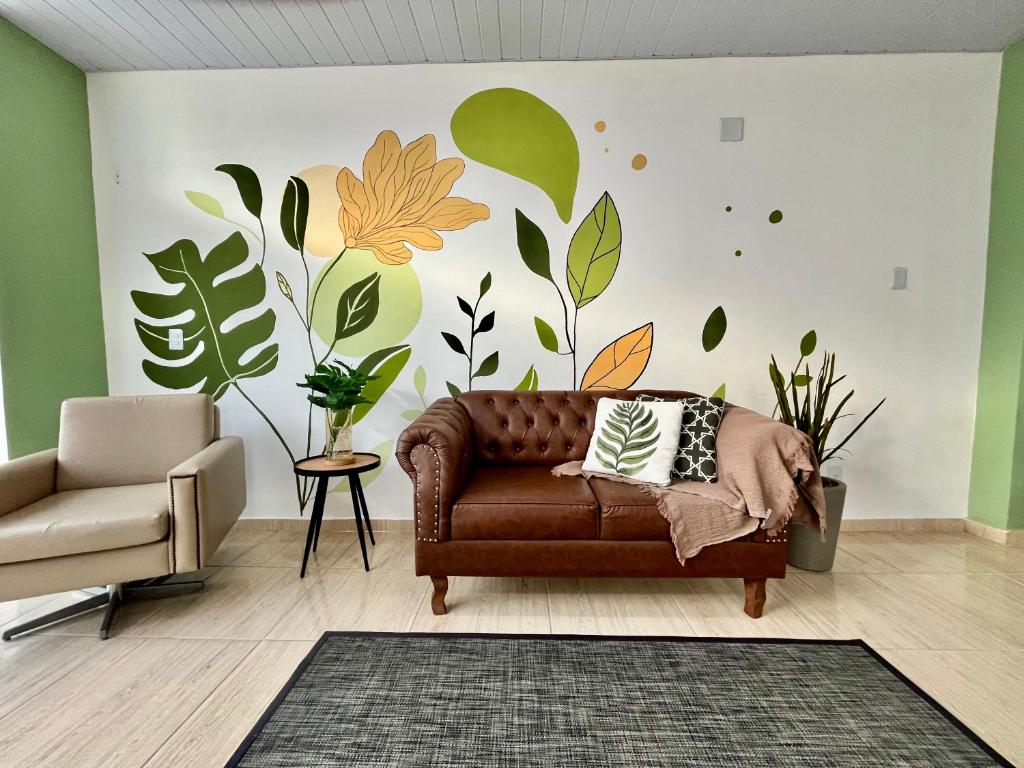 a living room with a couch and a wall with plants at Loft 967 in Itajaí
