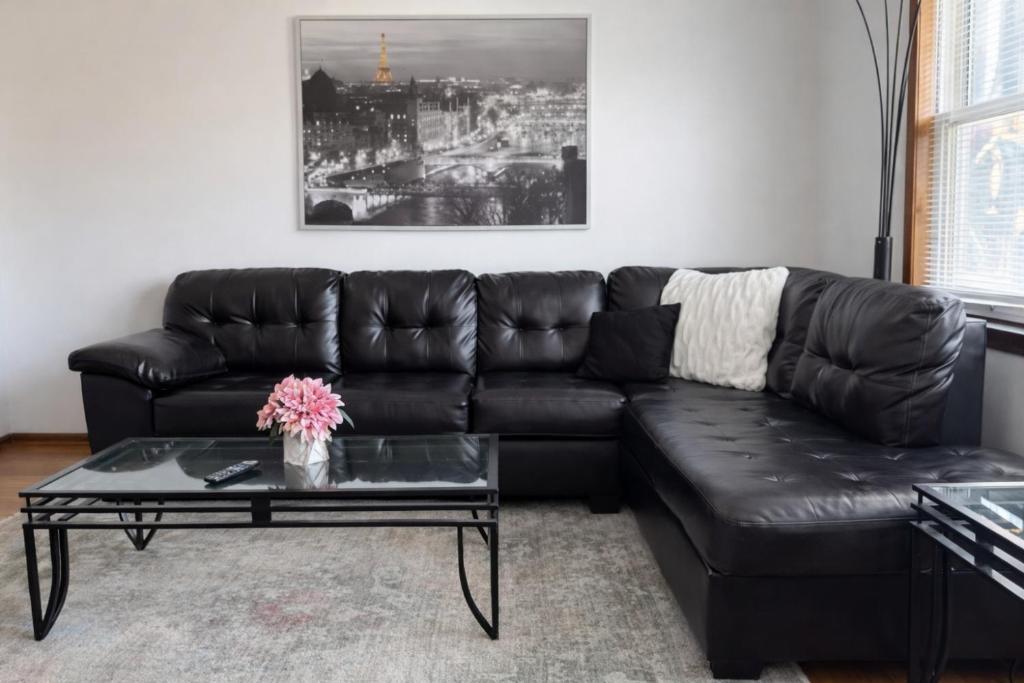 a black leather couch in a living room with a coffee table at Location! Location! 2bd 1bth spacious apartment! in Chicago