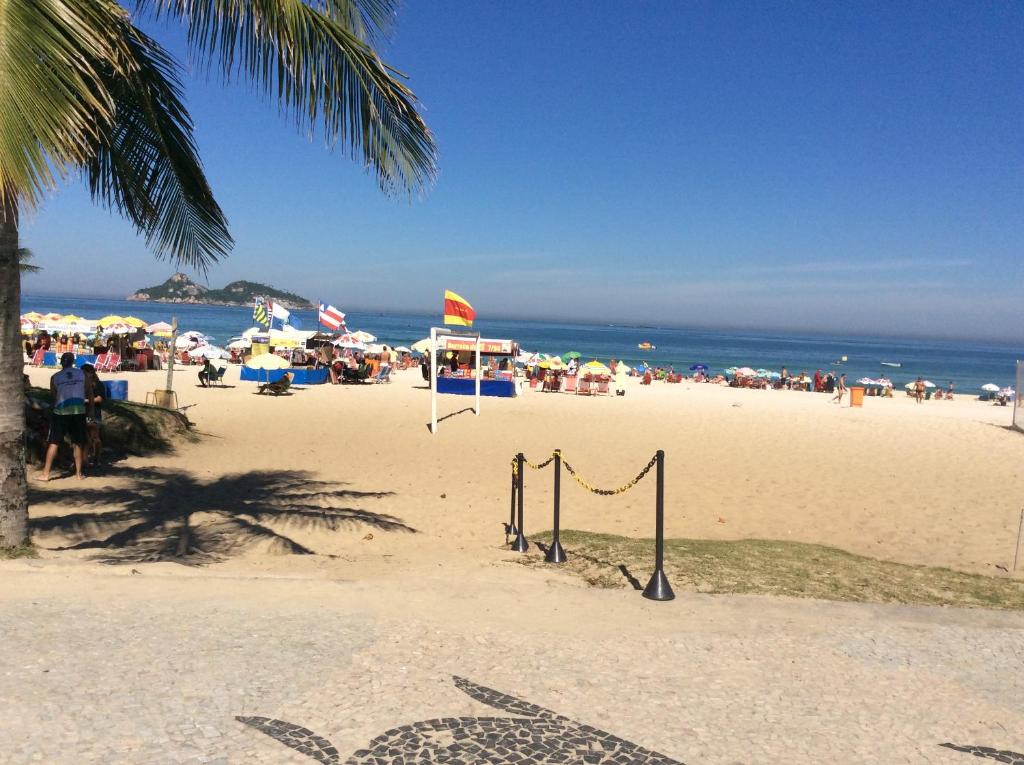 una playa con una red de voleibol y una multitud de personas en Apartamento Praia do Pepê en Río de Janeiro