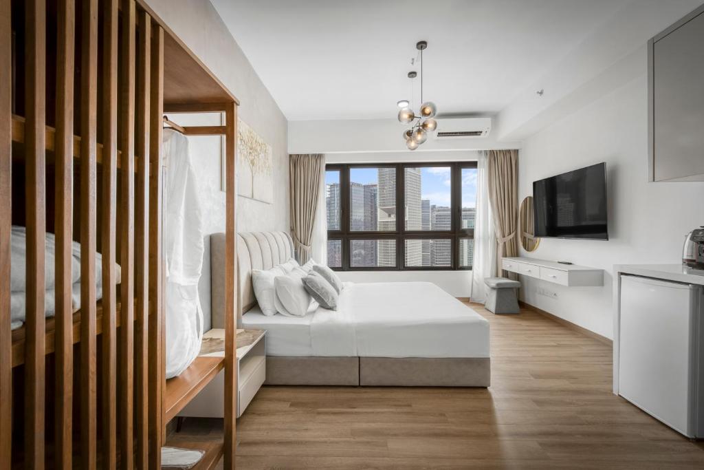 a bedroom with a white bed and a tv at Cavera Bukit Bintang in Kuala Lumpur