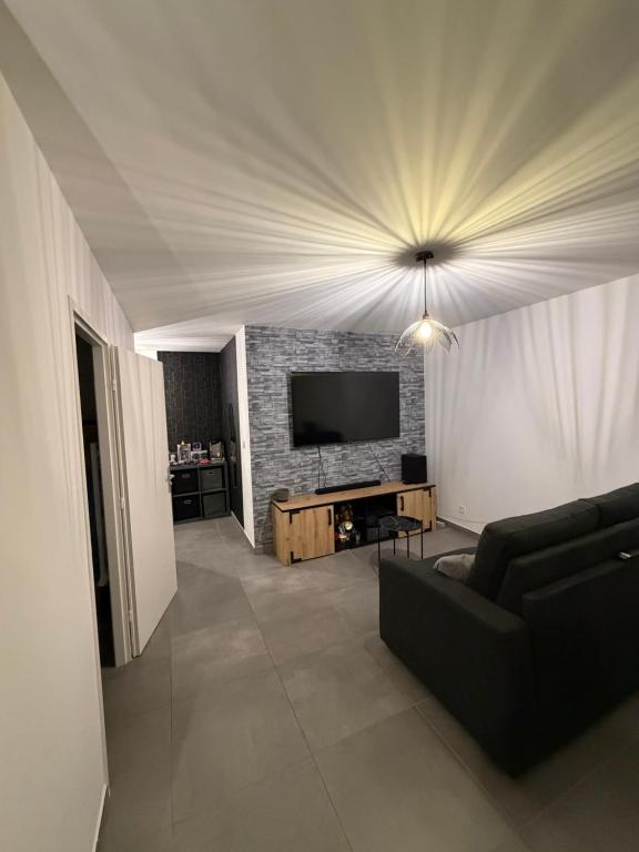a living room with a couch and a flat screen tv at Grand Studio Neuf in Ajaccio