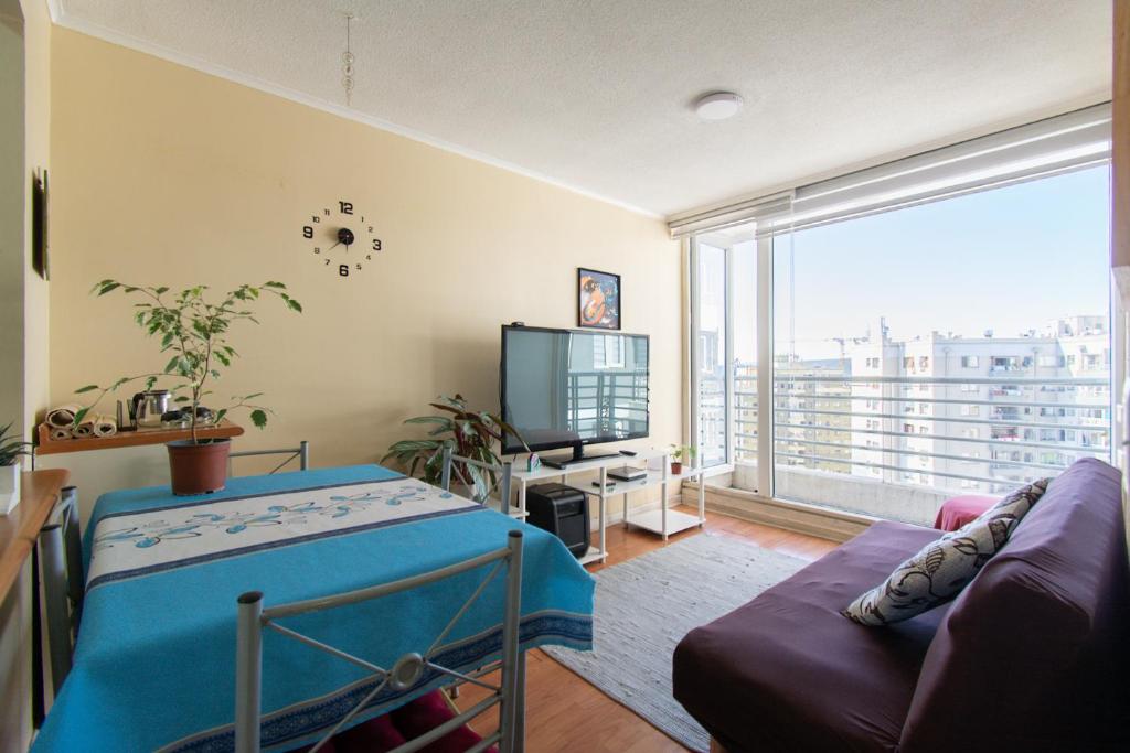 a living room with a couch and a large window at Alta vista Concepción in Concepción