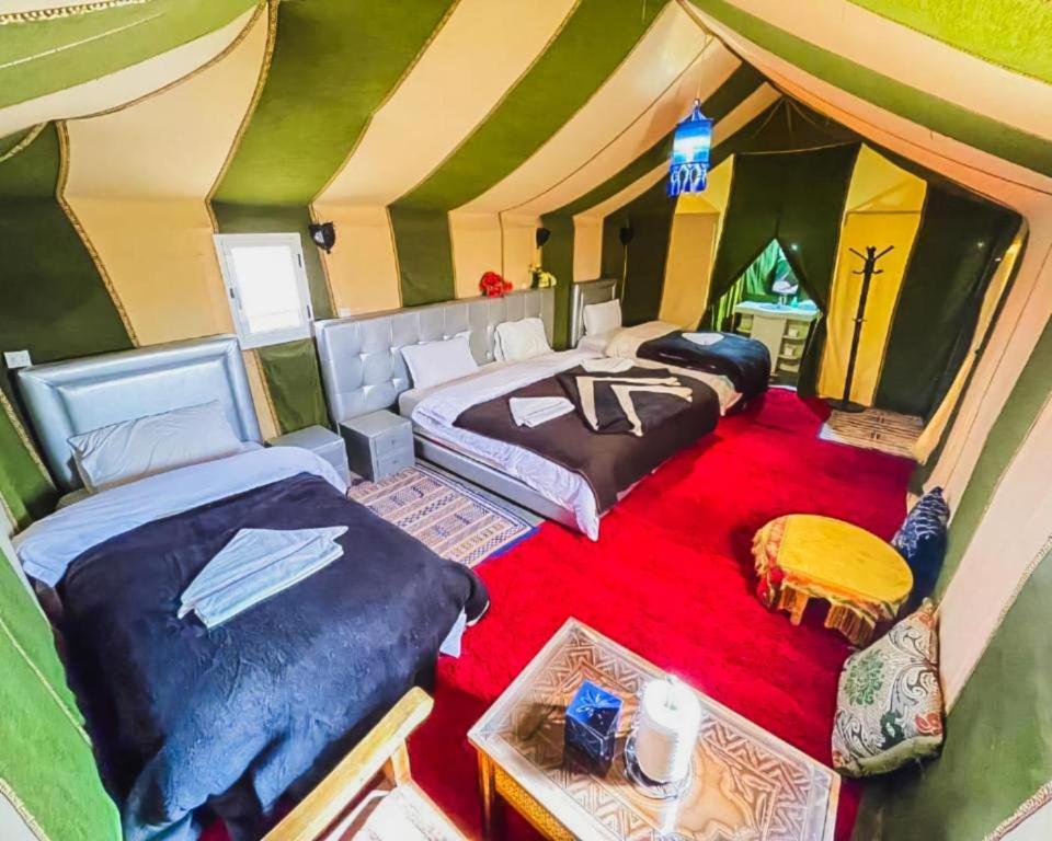 a room with two beds in a tent at Merzouga Traditional Camp in Merzouga