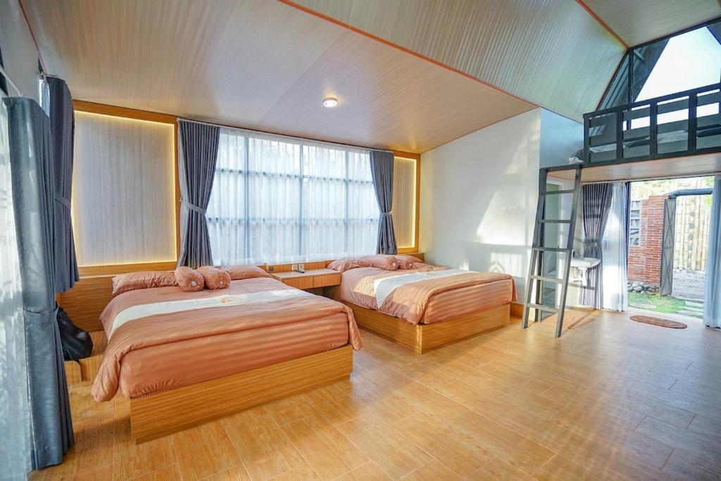 a bedroom with two beds and a bunk bed at Villa Kebon Paman in Balong