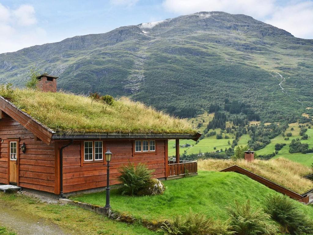 a house with a grass roof with a mountain in the background at 4 person holiday home in olden in Olden