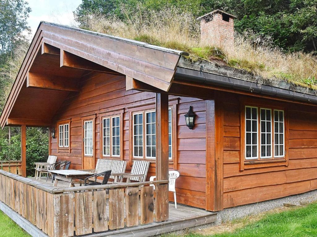 a log cabin with a table and chairs on a deck at 6 person holiday home in olden in Olden