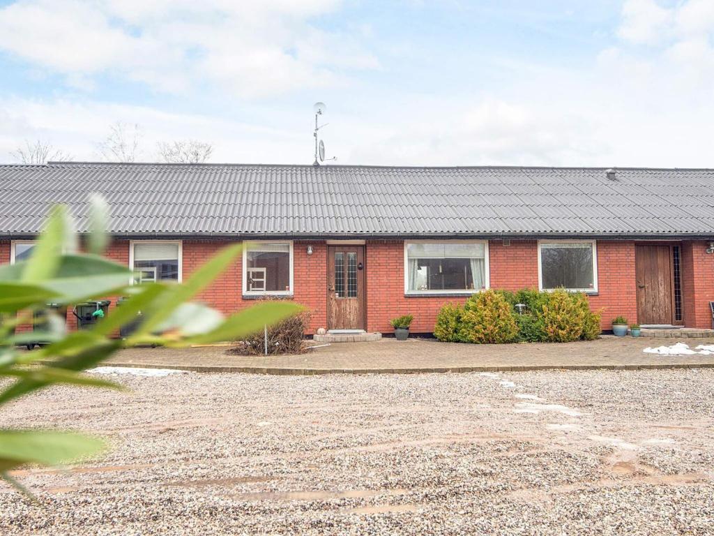a red brick house with a driveway in front of it at 4 star holiday home in Allingåbro in Allingåbro