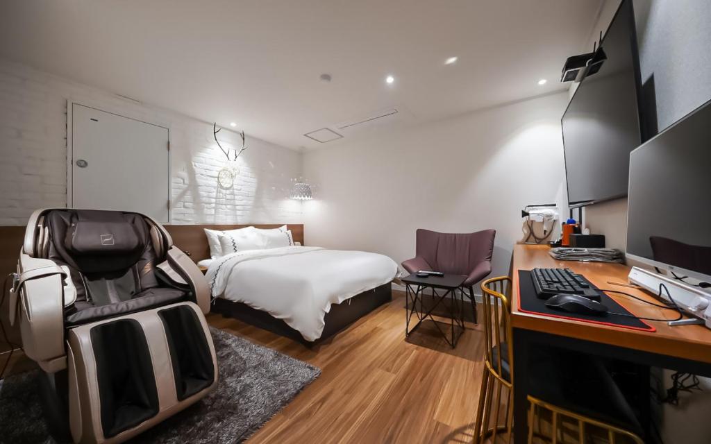 a bedroom with a bed and a desk with a computer at MARI hotel in Incheon
