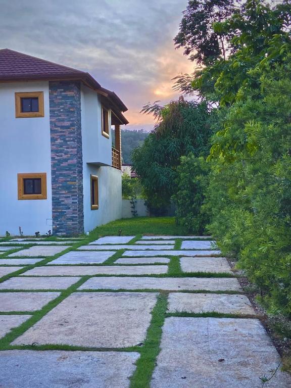 a stone path next to a house and a building at Villa Campo Verde in Jarabacoa