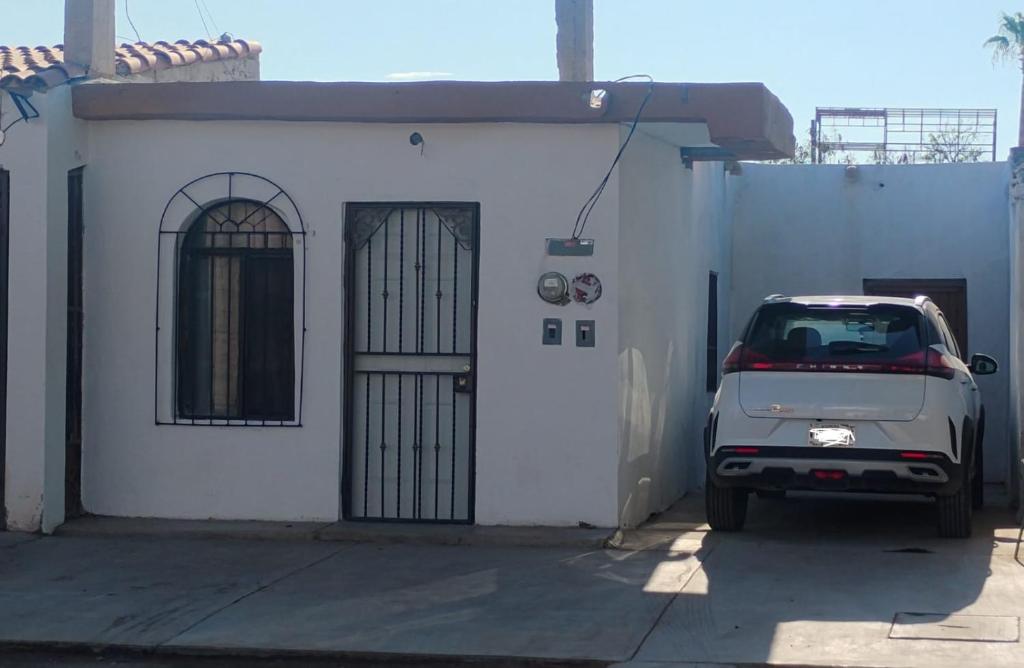 a small car parked in front of a white building at Casa centrica in Hermosillo