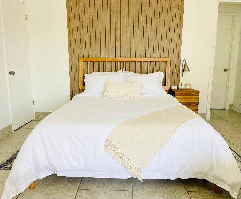 a bedroom with a large white bed with a wooden headboard at Downtown Studio Free Parking 1 mi to Beach & Convention Center in Long Beach