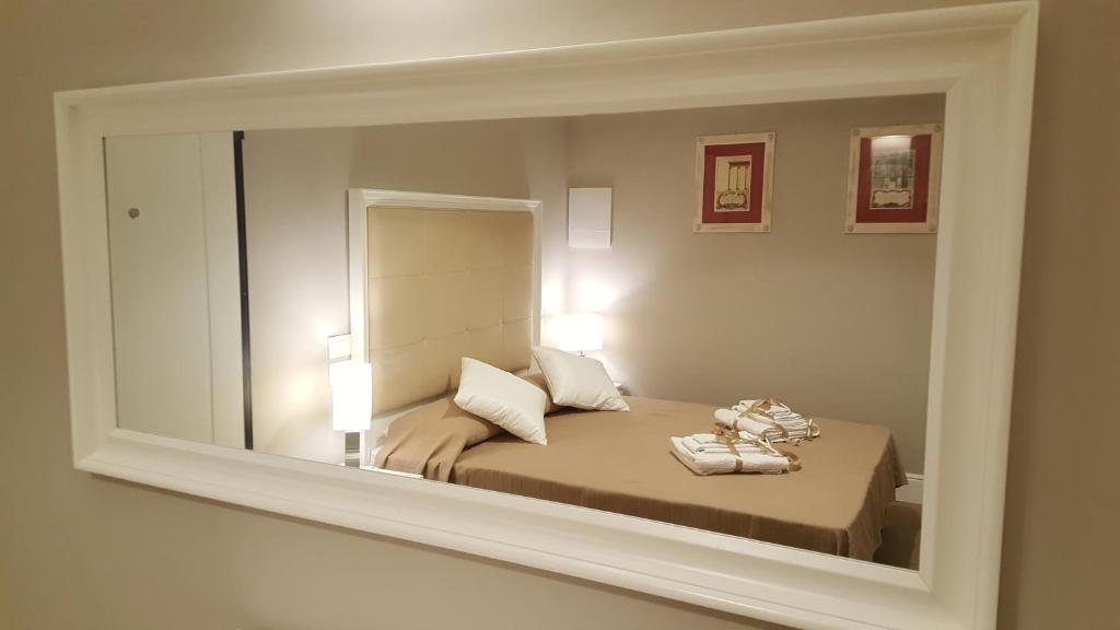 Scala Suite في فلورنسا: مرآة تعكس غرفة نوم مع سرير
