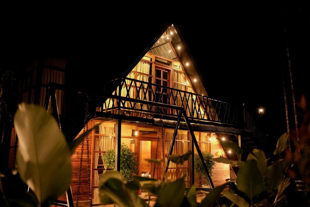 a house with a balcony with lights on it at Ethnic Villa Wayanad in Kenichira