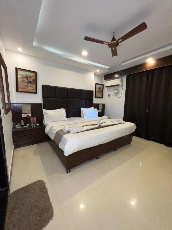 a bedroom with a large bed and a ceiling fan at Sportsman beach hotel in Calangute