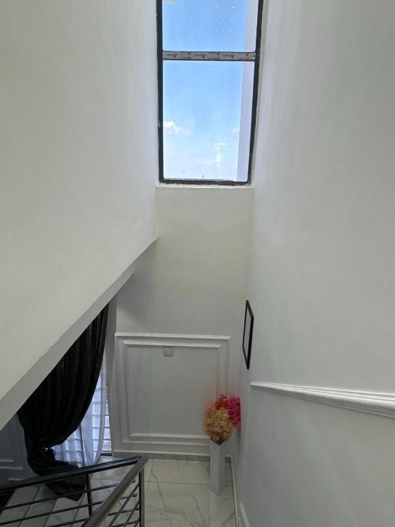 an attic stairway with a window and a plant at Luxueux duplex 2-bedroom in Ashalebotwe