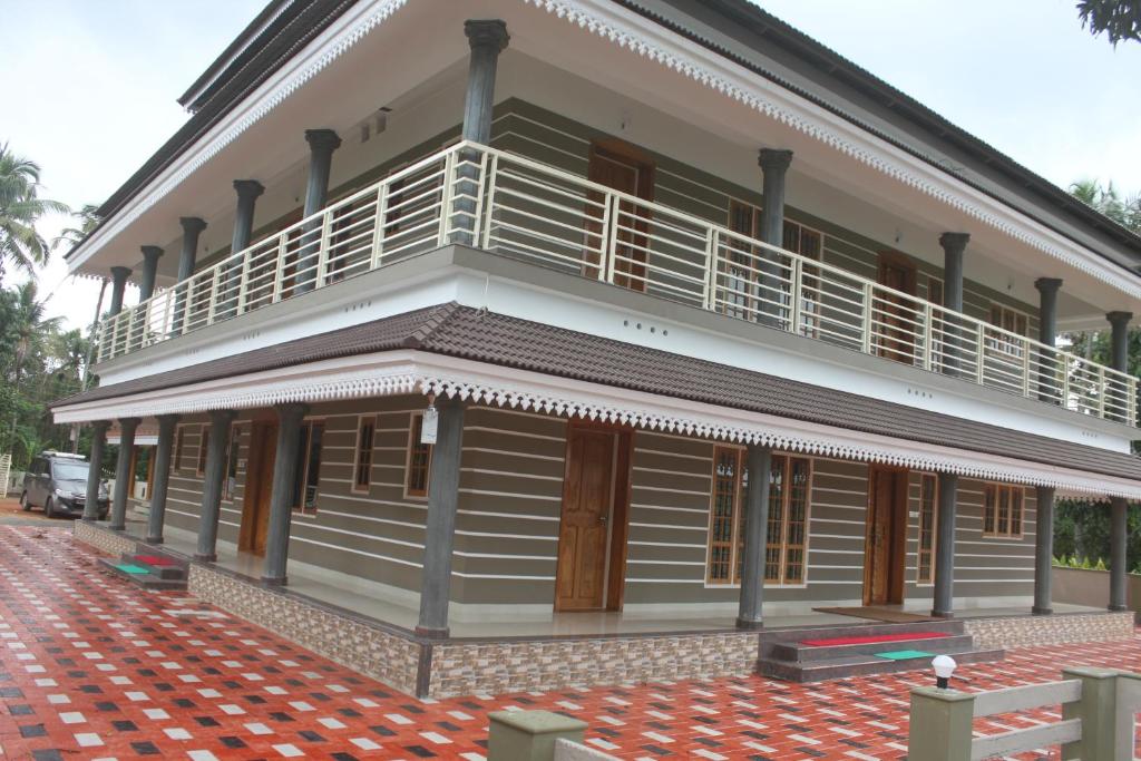 a building with a balcony on the side of it at SHANKARAM Homestay in Kodanad