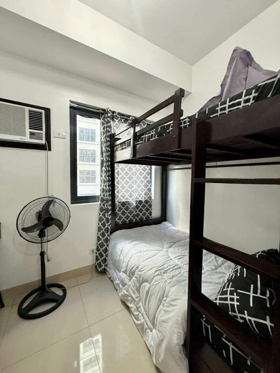 a bedroom with two bunk beds and a desk at Blanc Suite in Pasong Bayog
