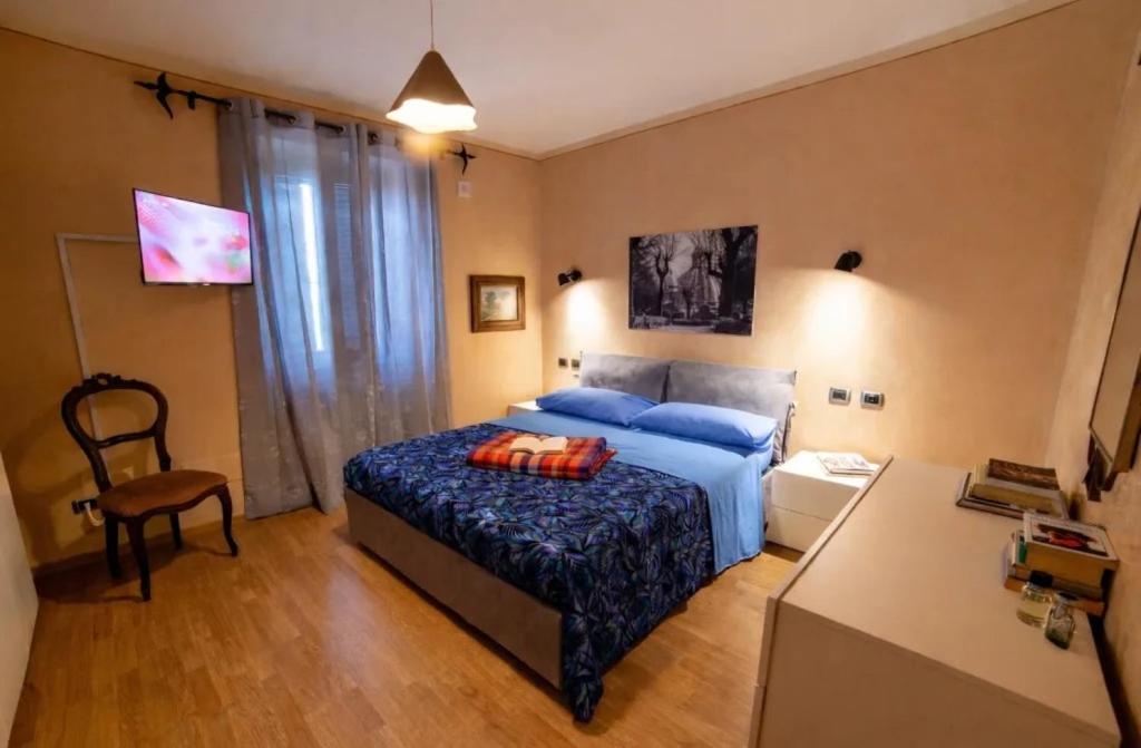 a bedroom with a blue bed and a desk and a chair at Tuscia Holidays in Zepponami