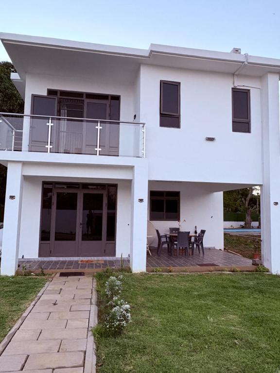 a white house with a patio and a table at Cool Breeze Villa No 2 in Grand-Baie