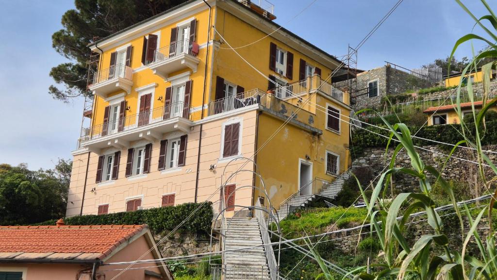 a yellow building on the side of a hill at Monterosso Apartments in Servano's Villas in Monterosso al Mare