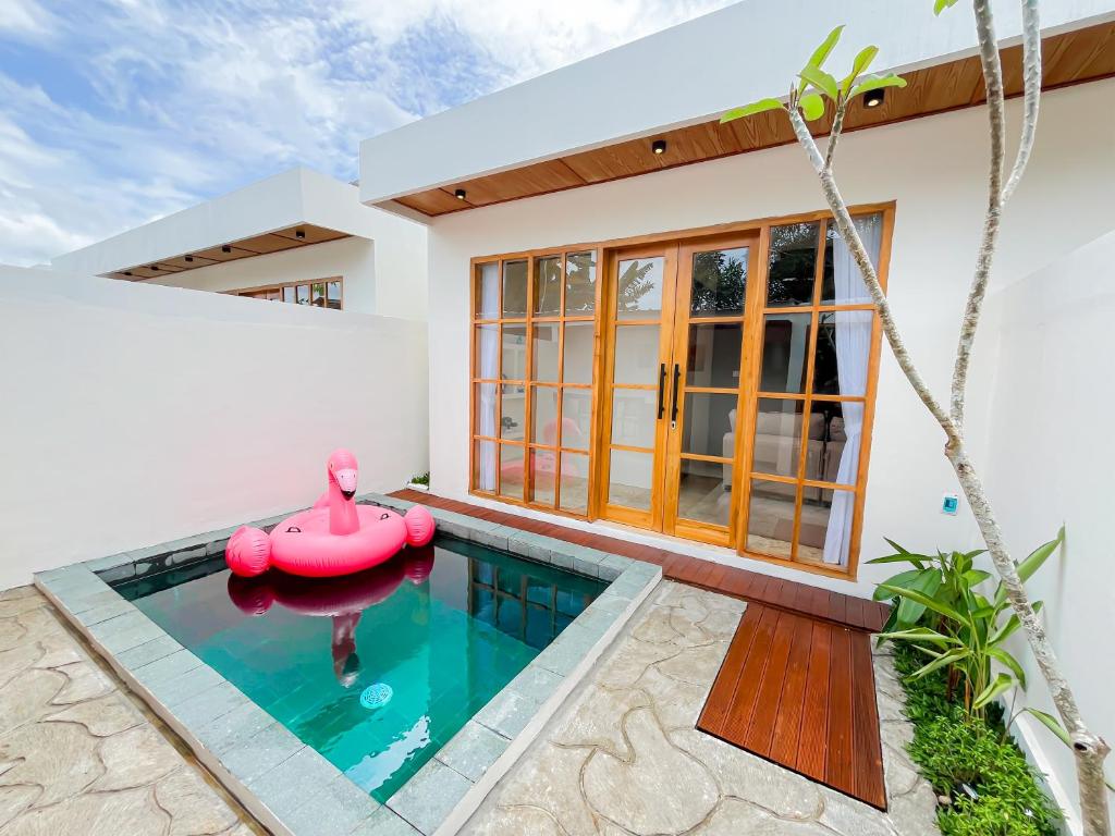a home with a swimming pool in front of a house at Among Villa Demangan in Yogyakarta