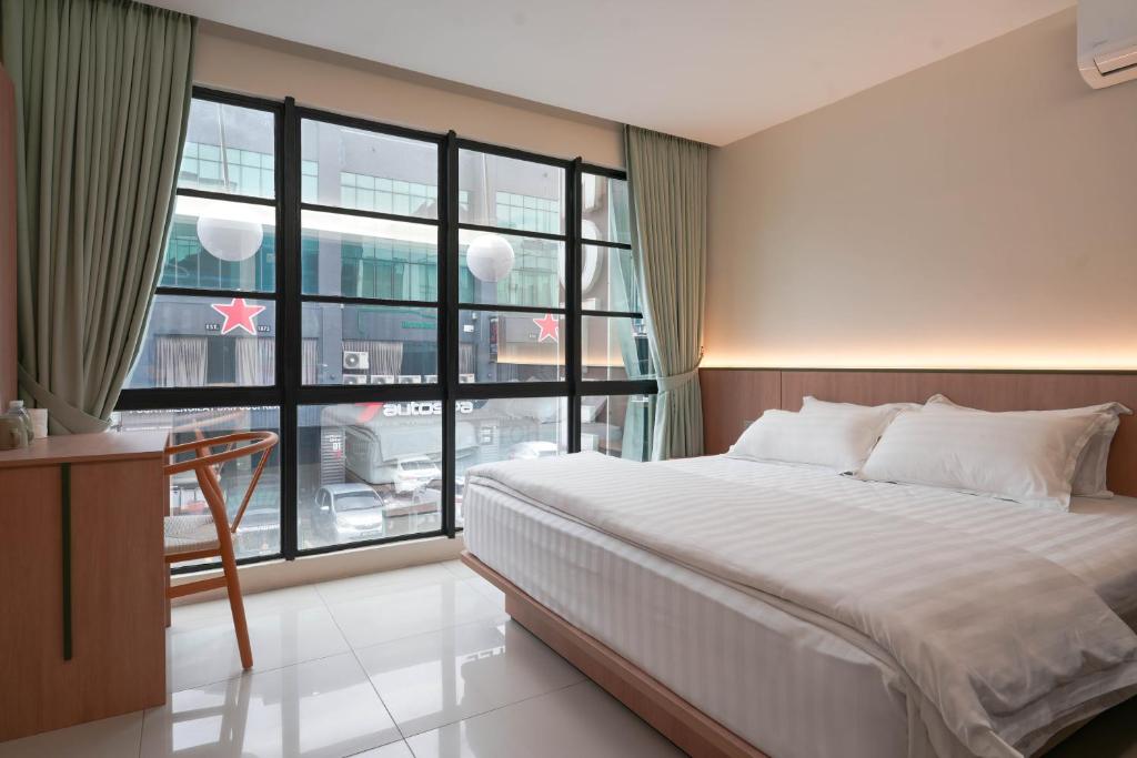 a bedroom with a large bed and a large window at Green Hotel in Puchong