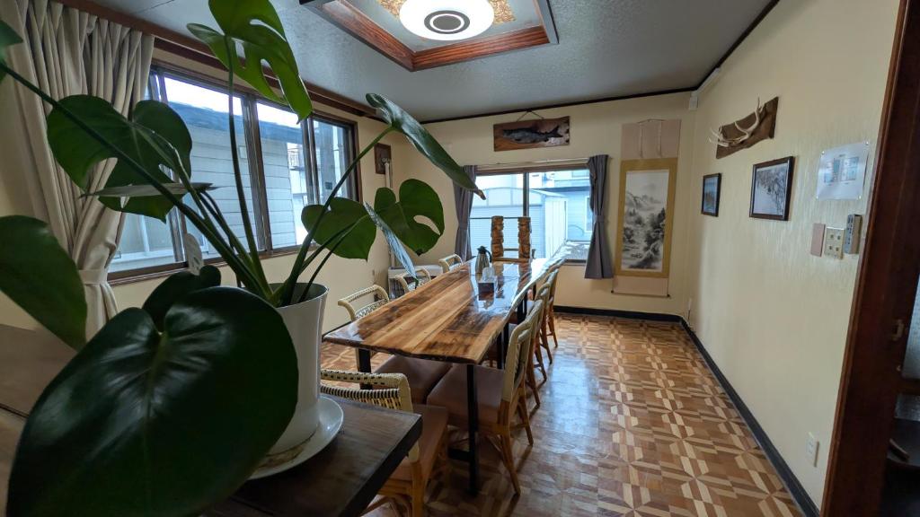 a dining room with a table and a potted plant at Tokachi Base Camp in Kami-furano