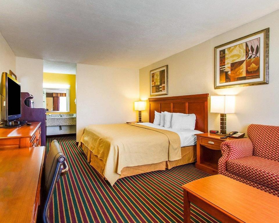 a hotel room with a bed and a chair at Quality Inn Dyersburg I-155 in Dyersburg