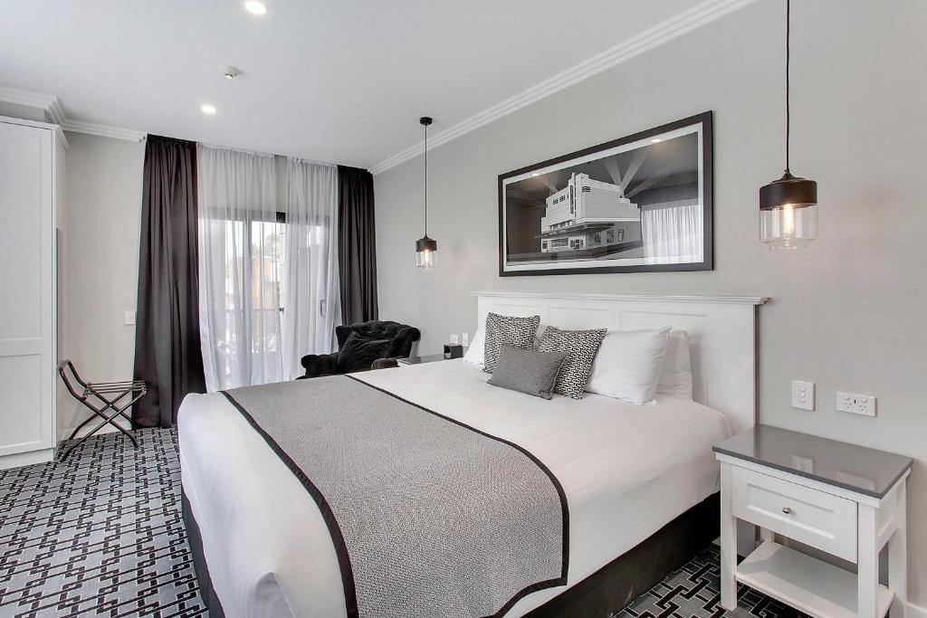 a hotel room with a large bed and a chair at CH Boutique Hotel, an Ascend Collection Hotel in Tamworth