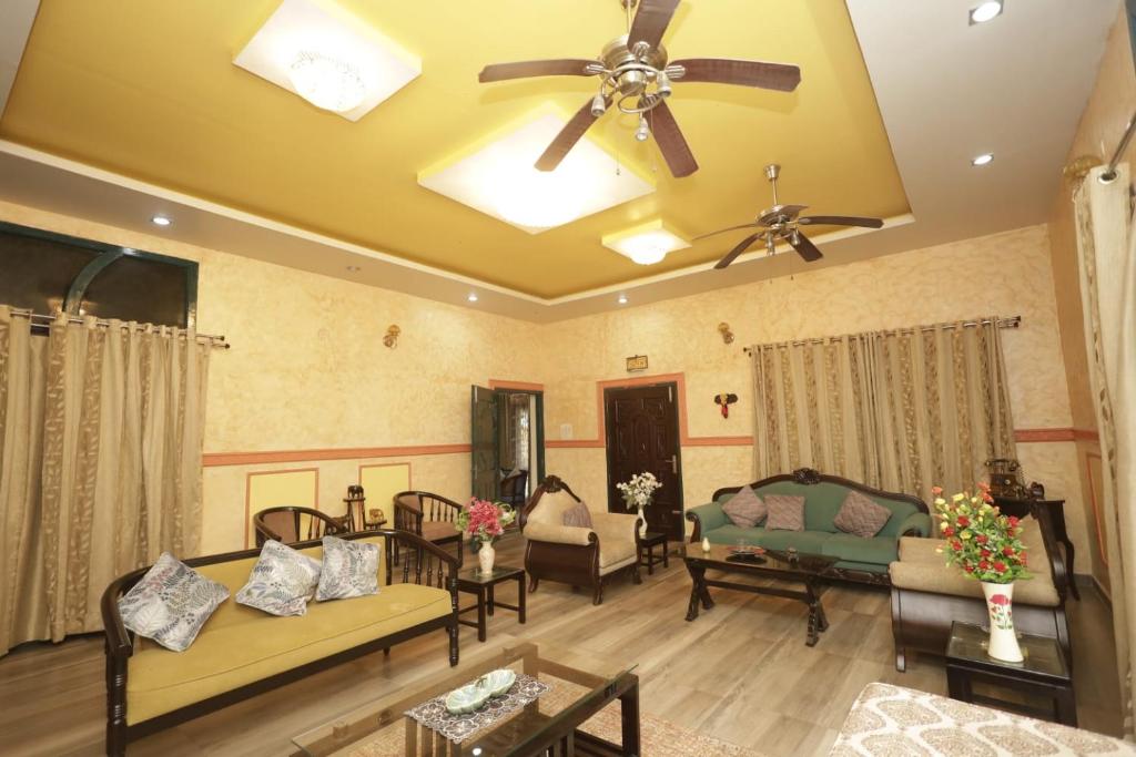 a living room with couches and a ceiling fan at Trisha Heritage in Dibrugarh
