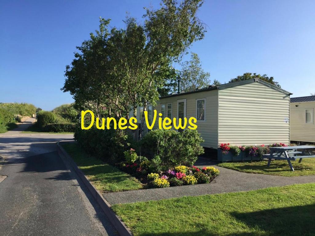 a house with a sign that reads dunes views at Dunes Views in Prestatyn