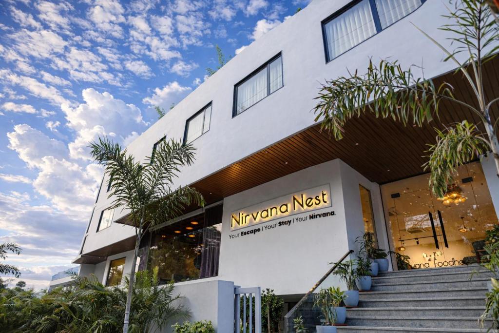 a white building with a nitschko nest sign on it at Nirvana Nest - Corporate Stay, Gomti Nagar, Lucknow in Lucknow