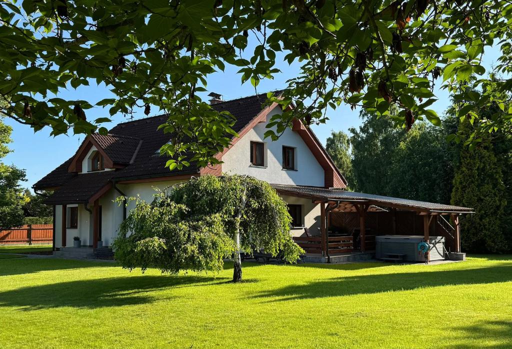 a white house with a tree in the yard at Dům pod horami - Beskydy in Frýdlant nad Ostravicí