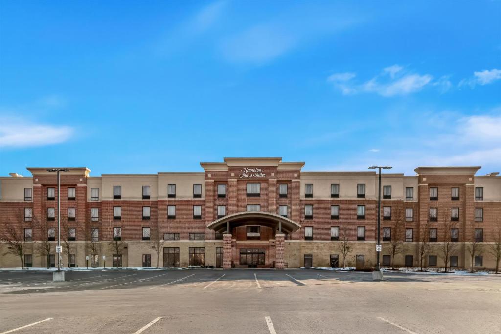 an empty parking lot in front of a large brick building at Hampton Inn & Suites Detroit-Canton in Canton