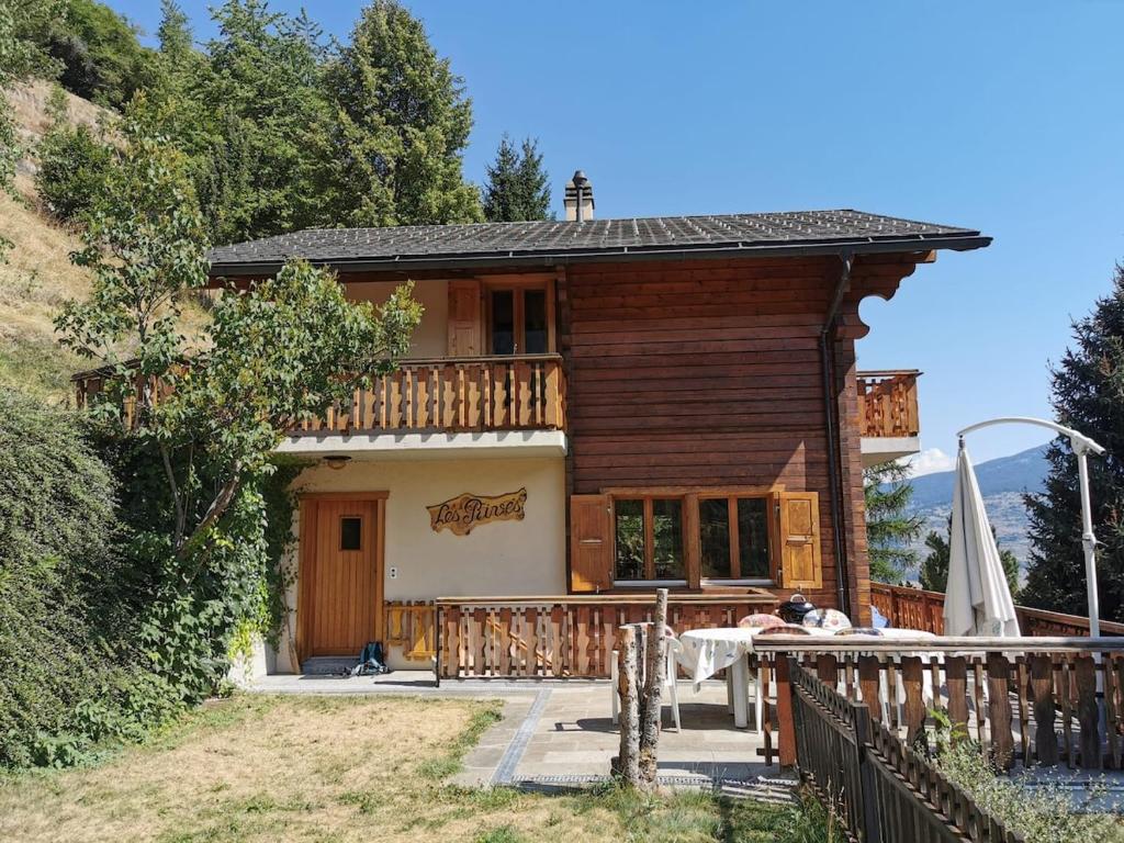 a wooden house with a table in front of it at Le balcon de Mâche in Hérémence