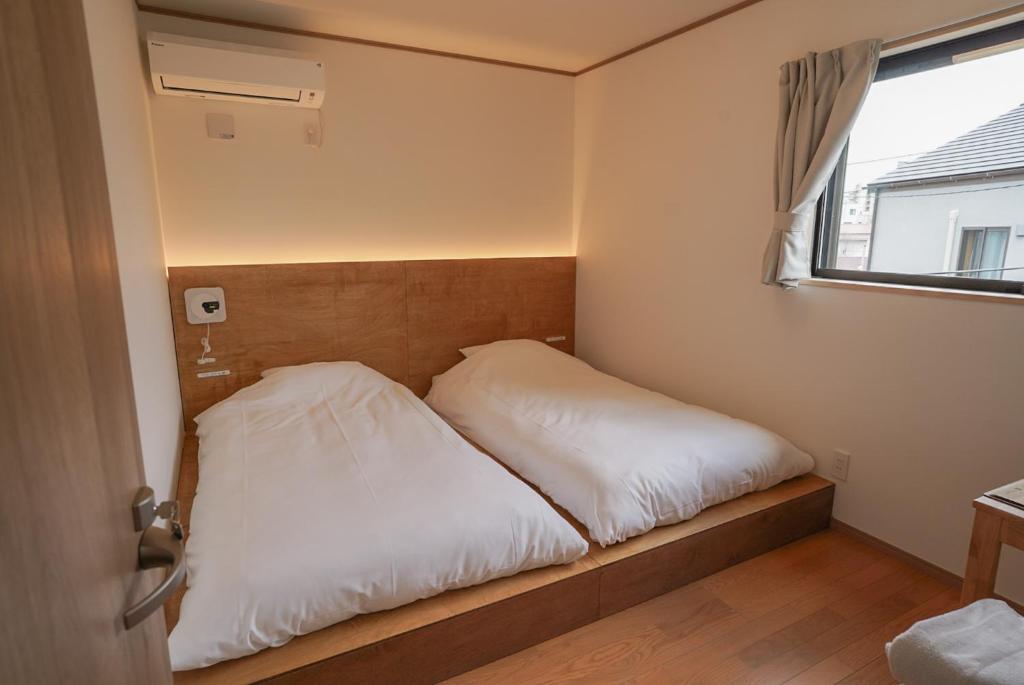 a bed in a small room with a window at Tipy records inn HALO in Odawara
