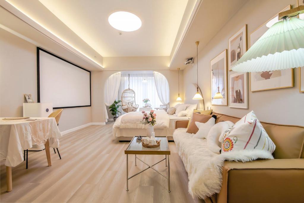 a living room with a couch and a table at 上海晶彩酒店式公寓江桥万达店 in Shanghai