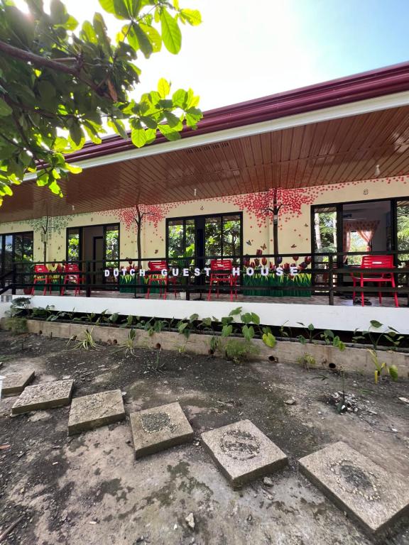 a building with tables and chairs in front of it at Dutch Guest House Studio in Siquijor
