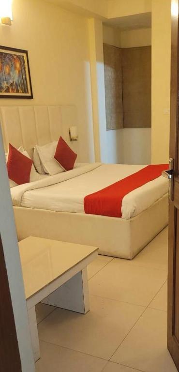a hotel room with two beds with red pillows at Tulip Palms in Jaipur