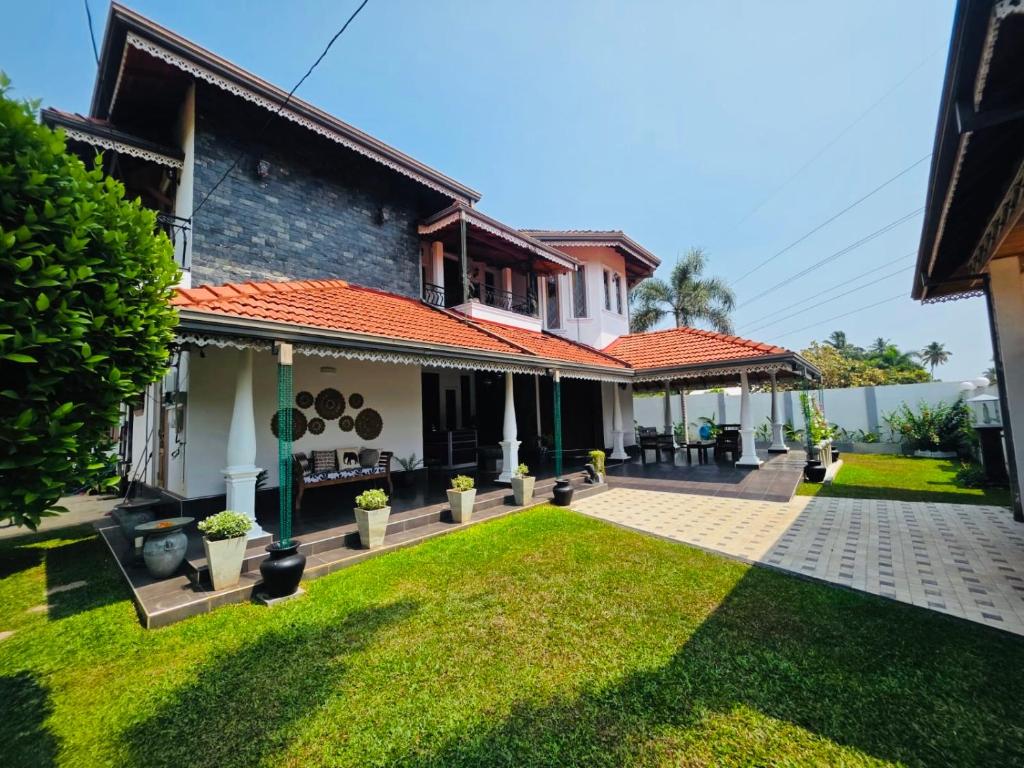 a house with a lawn in front of it at The Green Escape in Miriswatta