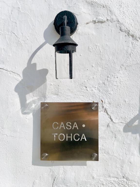 a sign on the side of a wall with a light at Casa Tohca Setenil in Setenil