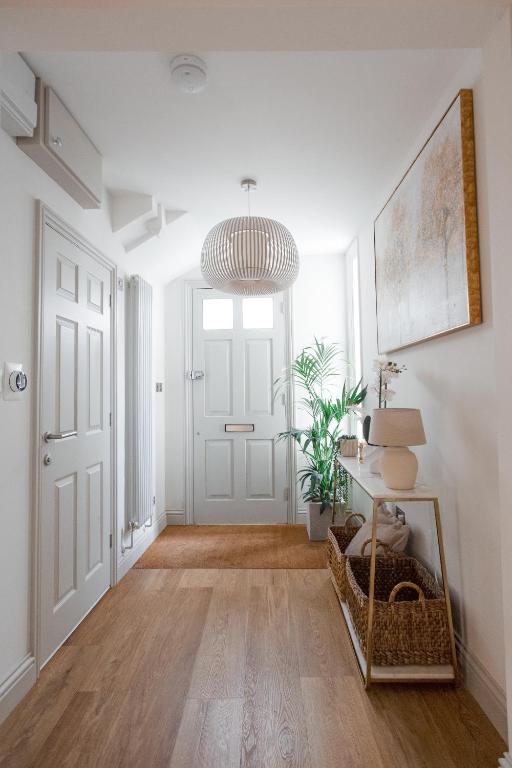 a hallway with a white door and a pendant light at Central Cheltenham Luxury Apartment – Edmonstone House in Cheltenham